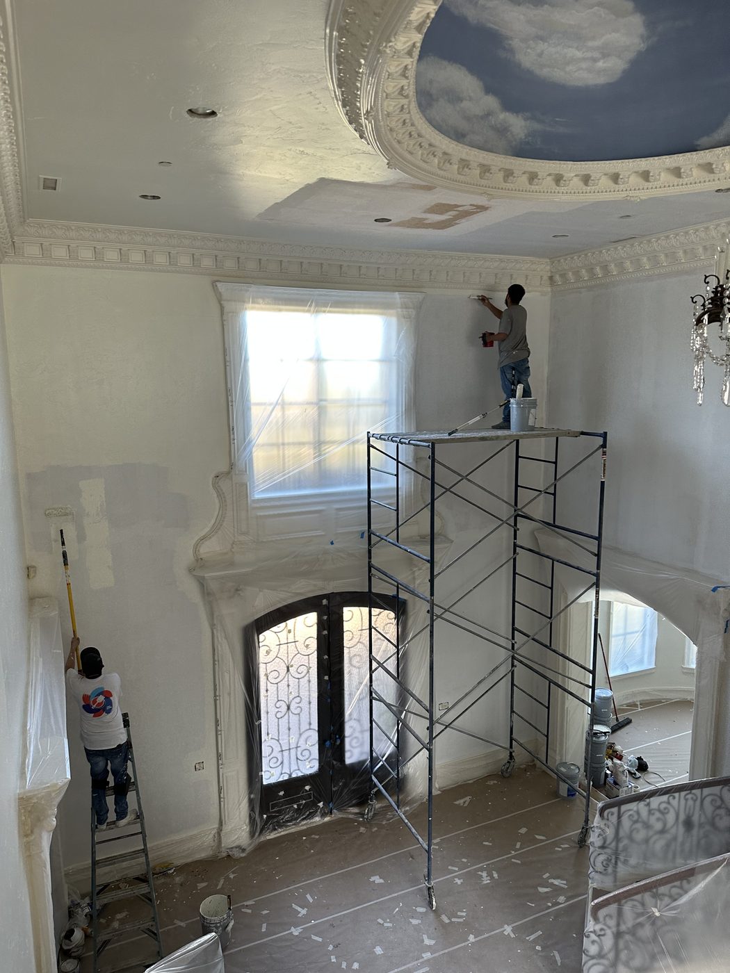 Dugco Construction crew painting a formal entry and staircase