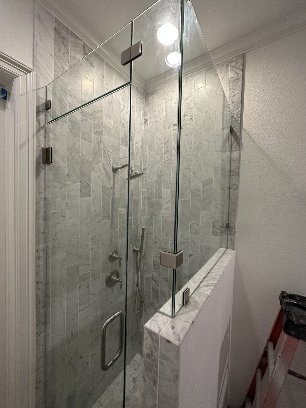 Frameless glass shower with marble tile